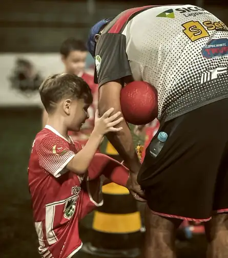 Treinador orientando um aluno no gramado