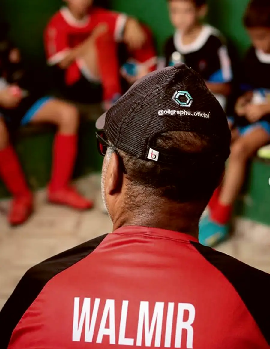 Walmir Franco de costas, com o nome na camisa, diante dos alunos